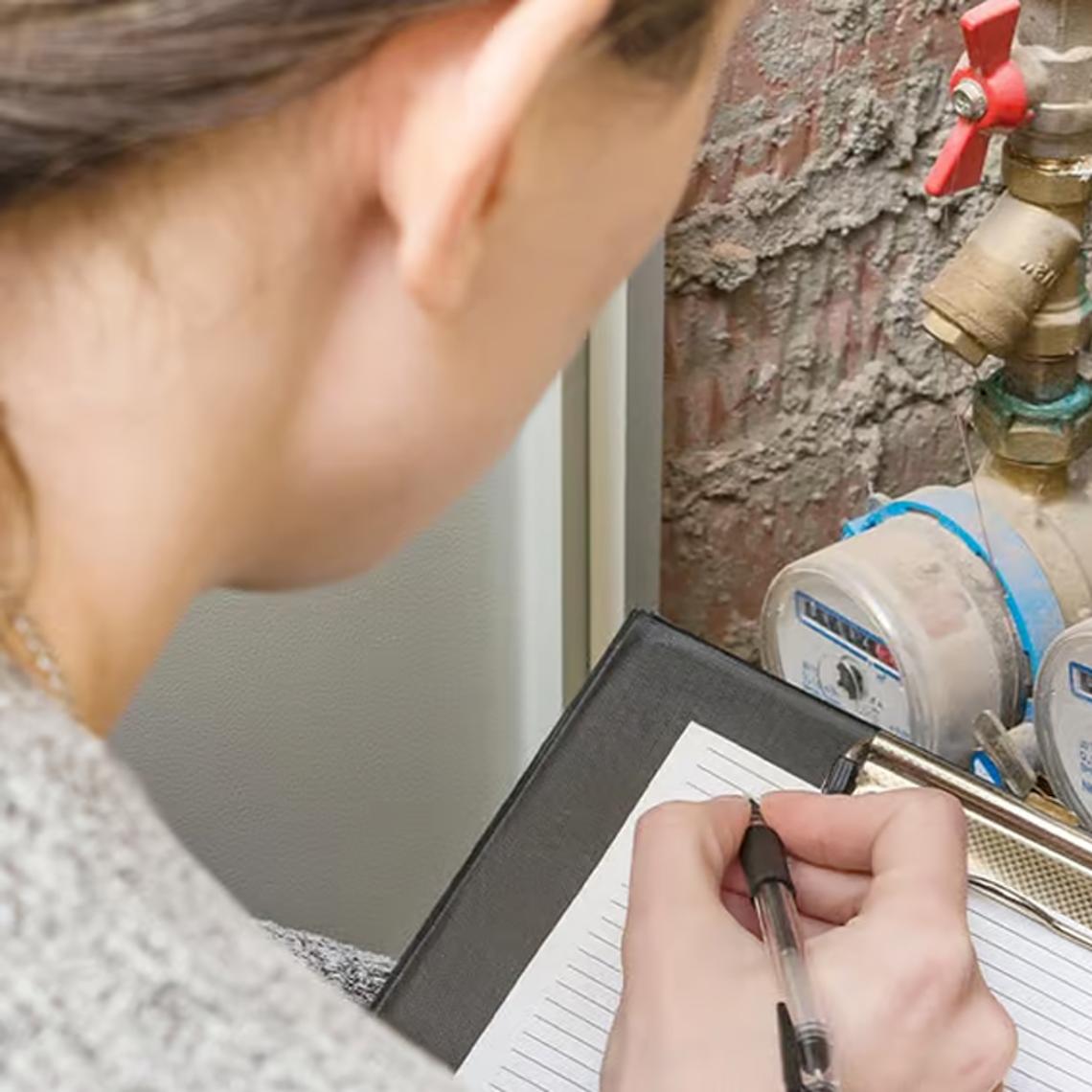 women taking a note of water meter reading
