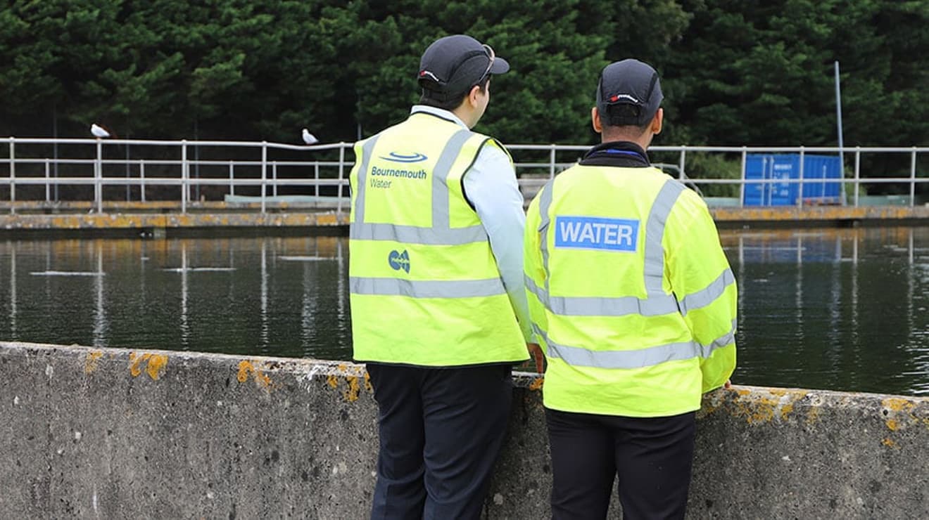 Two Bournemouth Water employees looking over treatment works