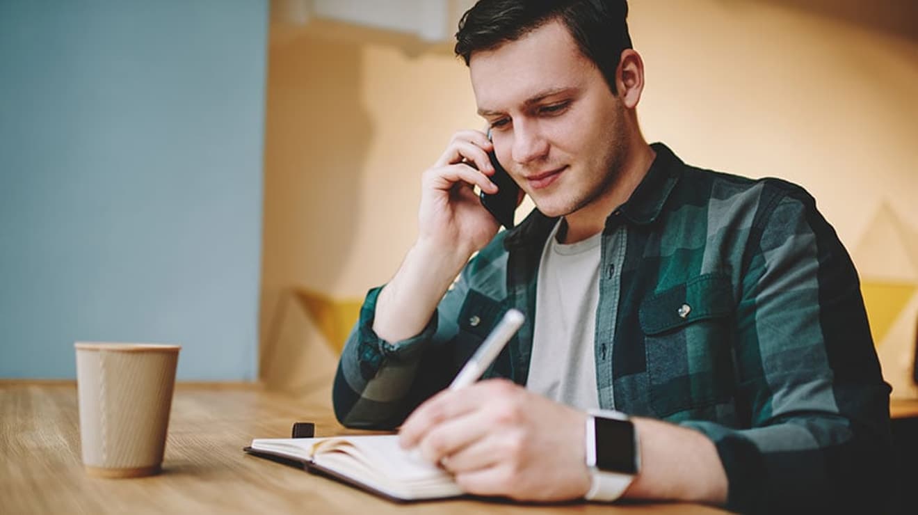 Man making notes on a phone call