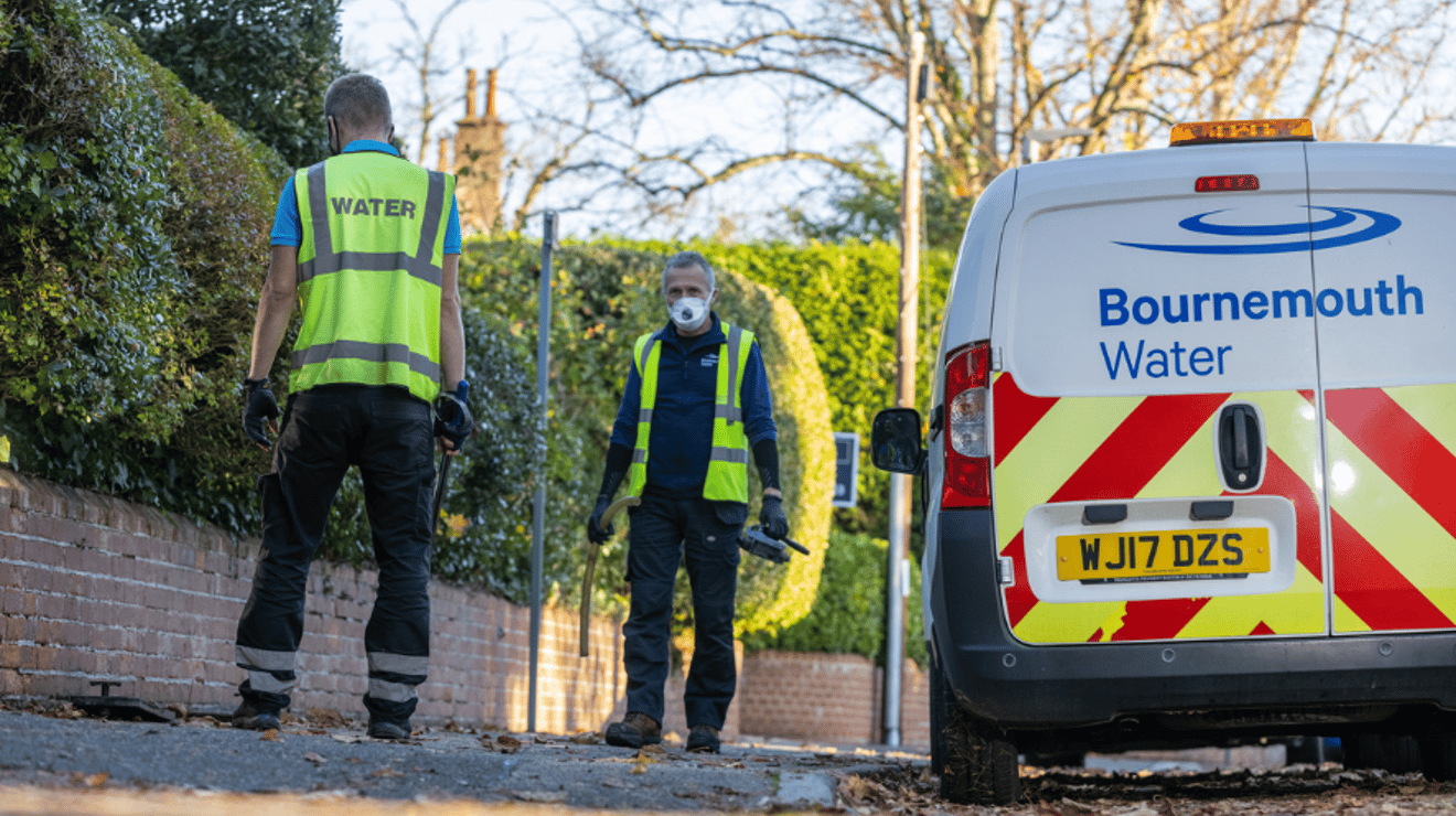Two Bournemouth Water Employees surveying the road next to a Bournemouth Water van