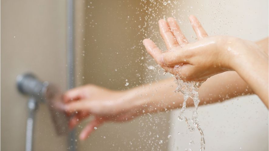 Two hands under a running shower
