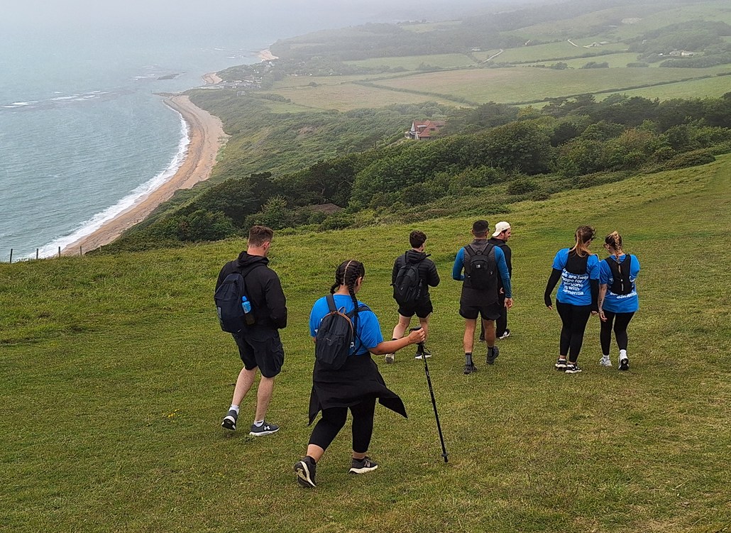 Bournemouth water employees walking down a hill with a view of the coastline