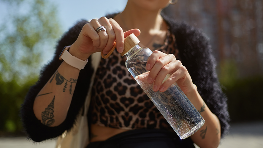 Close up of tattooed lady holding a reusable water bottle